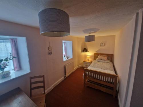 a small bedroom with a bed and a window at Forden House in Dolgellau