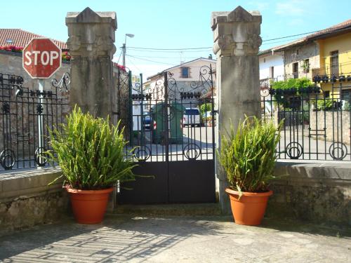 a gate with two potted plants and a stop sign at Posada Casa de Valle in Colindres