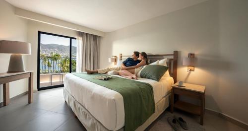 a couple sitting on a bed in a hotel room at Park Royal Beach Acapulco - All Inclusive in Acapulco