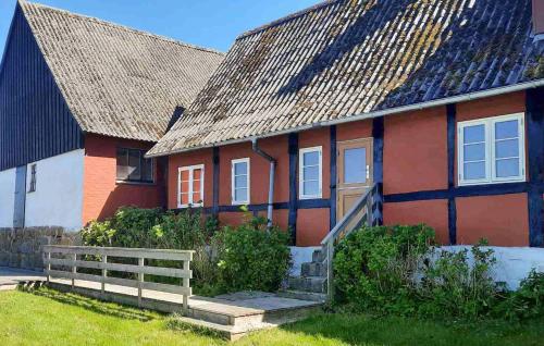 a red and white house with a porch and a fence at 3 Bedroom Cozy Home In Østermarie in Østermarie