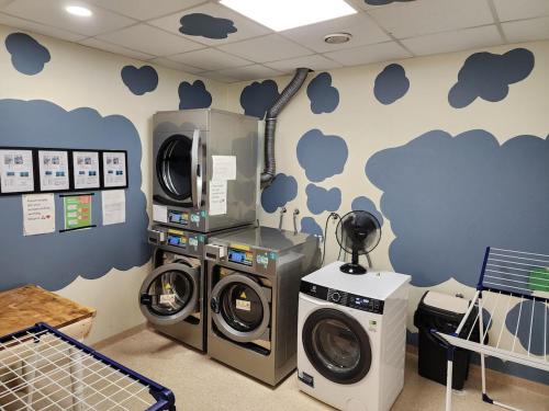 a laundry room with two washing machines and a microwave at Base apartments ap 207 - Capital region of Reykjavík in Hafnarfjördur