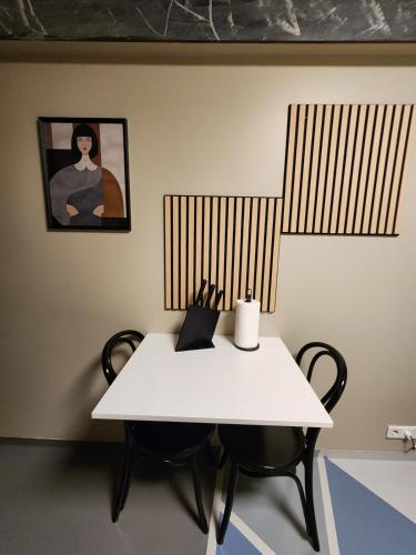 a white table and chairs in a room with a painting at Base apartments ap 207 - Capital region of Reykjavík in Hafnarfjördur