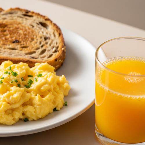 Un plato de huevos y tostadas junto a un vaso de jugo de naranja en Casa De Terena, en Terena