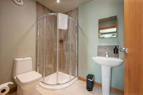 a bathroom with a shower and a toilet and a sink at Oban House House in Oban