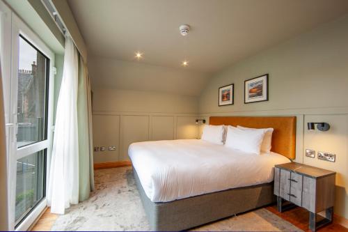 a bedroom with a bed and a large window at Oban House House in Oban