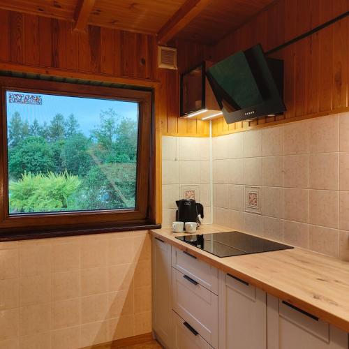 a kitchen with a window and a counter with a sink at Mazurski oddech in Zgon