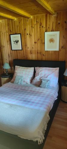 a bed in a room with wood paneled walls at Mazurski oddech in Zgon