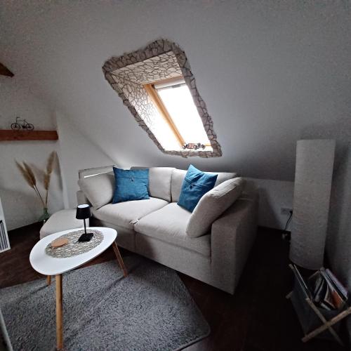 a living room with a couch and a mirror at Schulzis Ferienwohnung in Windeck