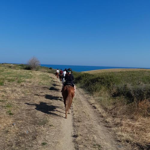 a group of people riding horses down a dirt road at Le Mignole in Orsogna