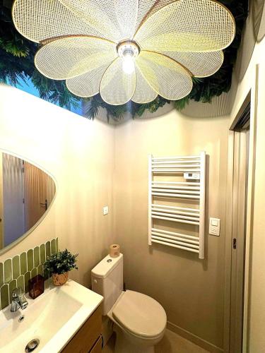 La salle de bains est pourvue de toilettes et d'un ventilateur de plafond. dans l'établissement La Cachette Sauvage au cœur de Villefranche, à Villefranche-sur-Saône