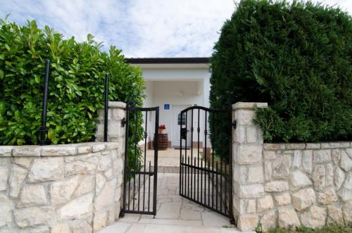 a gate to a house with a stone wall at Holiday Home Mia in Labin