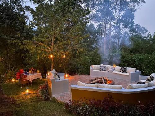 a patio with couches and a fire pit in a yard at Gorilla Safari Lodge in Rubuguli