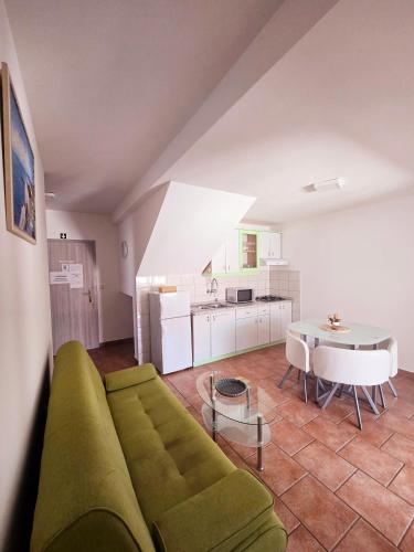 a living room with a green couch and a table at Apartments Vugica Šilo in Šilo