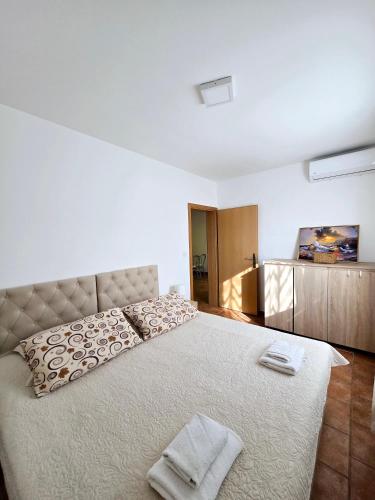 a bedroom with a large bed with two towels on it at Apartments Vugica Šilo in Šilo