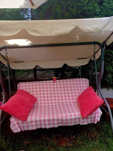 a picnic table under a tent with two red cushions at Sweet Home in Valjevo