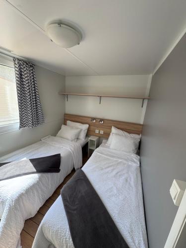 a room with three beds and a window at Mobile Home Nelly 775 in Biograd na Moru