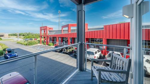 a balcony with a red building and a parking lot at Rodanthe Pier - 2-Bedroom, 2-Bathroom Suite at REAL Watersports in Waves