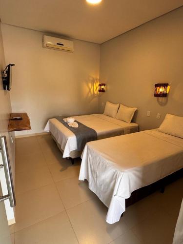 a hotel room with two beds in a room at Chalés da Chapada in Carolina