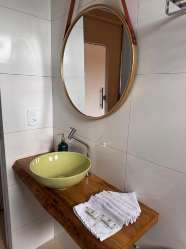 a bathroom with a green bowl sink and a mirror at Chalés da Chapada in Carolina