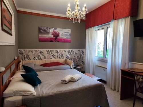 a bedroom with a bed and a chandelier at Hotel Minerva in Ravenna