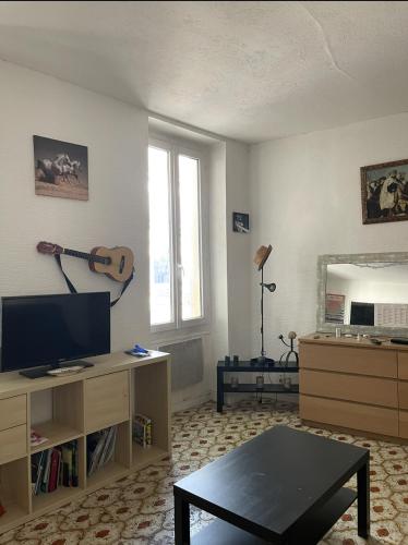 - un salon avec une guitare sur le mur dans l'établissement Appartement confortable au centre de Marseille, à Marseille