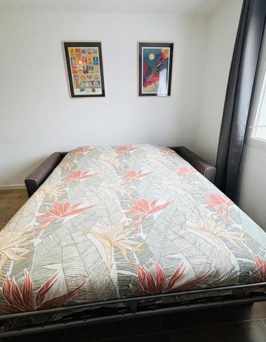 - un lit dans une chambre ornée de motifs floraux dans l'établissement Studio calais la plage, à Calais
