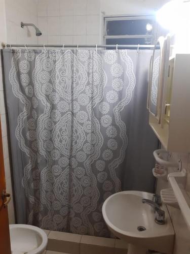 a bathroom with a shower curtain and a sink at Alquiler Corral de Bustos in Corral de Bustos