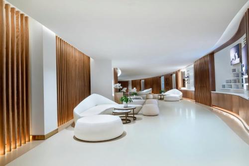 a lobby of a hotel with white chairs and tables at The St. Regis Marsa Arabia Island, The Pearl Qatar in Doha