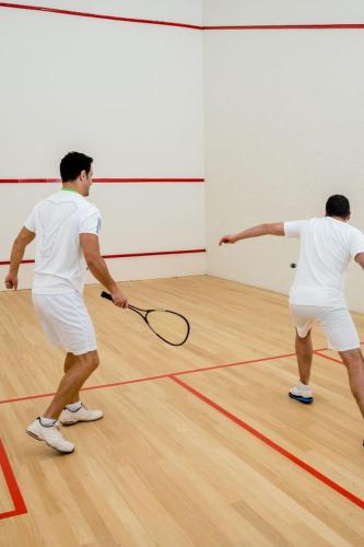 two men playing a game of tennis on a court at Private Oasis at Arya in Miami