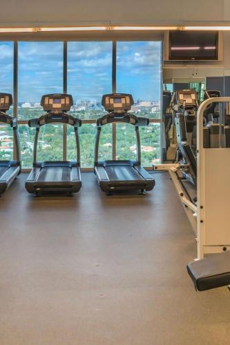 a gym with several treadmills in front of a large window at Private Oasis at Arya in Miami