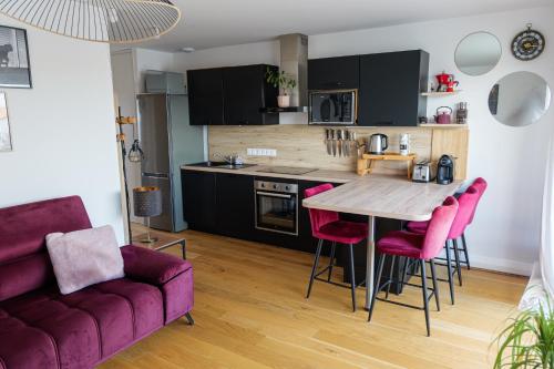 une cuisine avec une table en bois et des chaises rouges dans l'établissement La Parenthèse Sablaise, à Les Sables-dʼOlonne