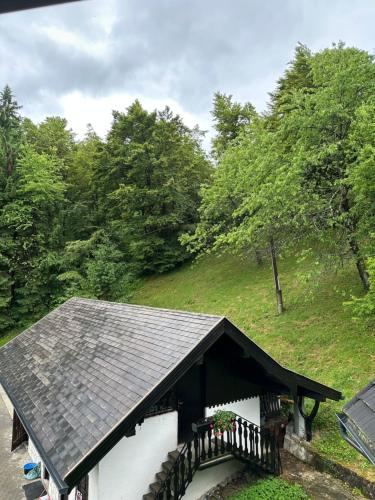 a house with a black roof and a balcony at Planinska koča na Kopitniku in Dol pri Hrastniku