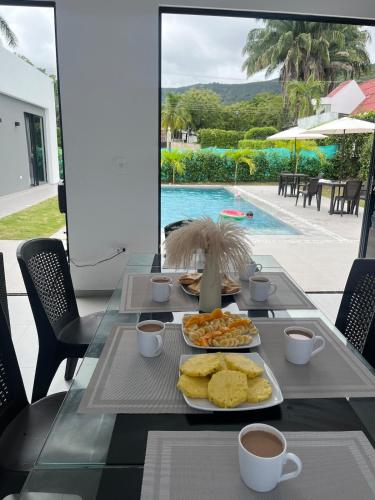 a table with breakfast foods and coffee and a pool at Mint House Escape in Ricaurte