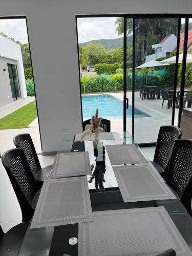 a dining room with tables and chairs and a pool at Mint House Escape in Ricaurte