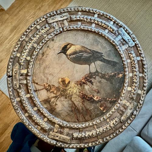 a bird sitting on a plate with a painting on it at Muddy Boots-Arcade Royale in Kirkby Stephen
