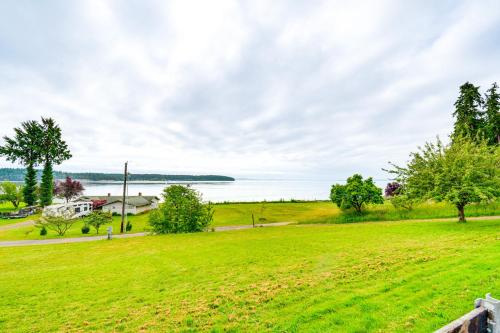 a green field with a view of the water at 11 Mi to Port Townsend Ferry Cottage with View! in Port Hadlock