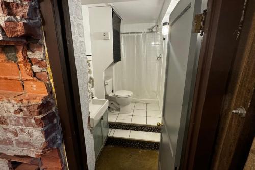 a small bathroom with a toilet and a shower at Main Street Suites Nanton in Nanton