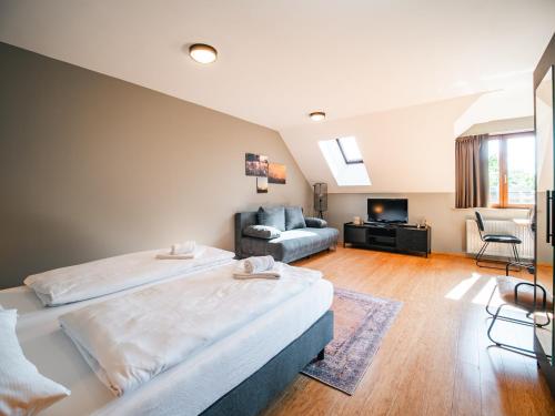 a hotel room with two beds and a couch at Feriendorf Rosental by S4Y - Selbstversorger Appartements in Feistritz im Rosental