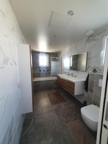 une salle de bain avec toilettes, baignoire et lavabo dans l'établissement villa with swimming pool, à Juvignac