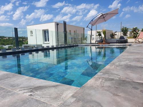 une piscine avec de l'eau bleue devant un immeuble dans l'établissement villa with swimming pool, à Juvignac