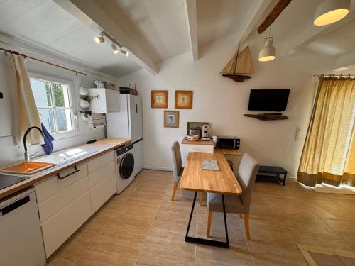 une cuisine avec une table et une salle à manger dans l'établissement Coup de cœur ! Maisonnette neuve à 300 m du port et de la plage, à L'Ile d'Yeu