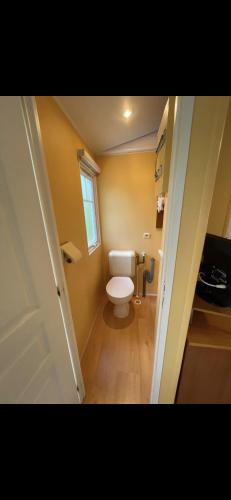 Elle comprend une petite salle de bains pourvue de toilettes et d'une fenêtre. dans l'établissement Bungalow TORNADO climatisé avec 3 chambres, à Saint-Laurent