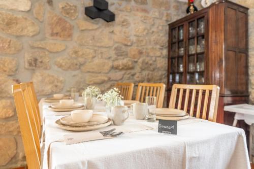 a table with a white tablecloth and plates on it at Casa d'Amares in Amares