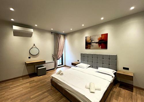 a bedroom with a large bed and a mirror at Qabala Twins Villa two in Gabala