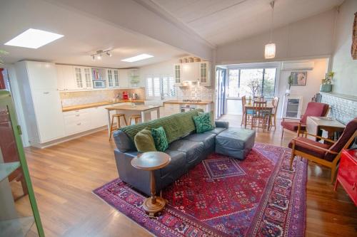 a living room with a couch and a kitchen at Bylund Cottage in Albany