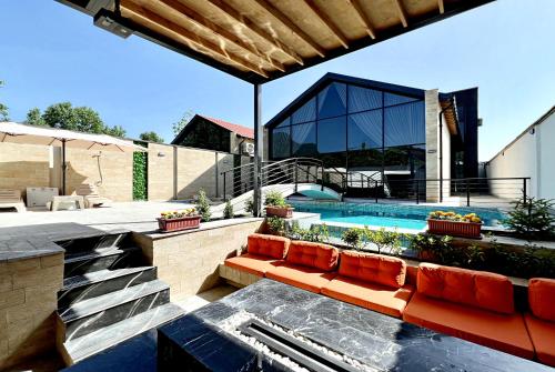 a house with a swimming pool with a red couch at Qabala Twins Villa two in Gabala