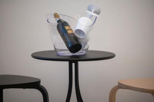 a glass vase with a bottle on a table at La zagara di Alba in Palermo