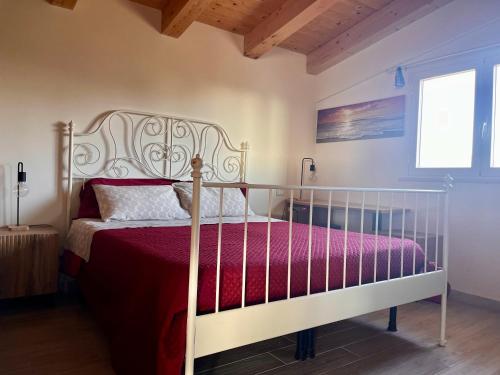 a bedroom with a white bed with a red comforter at The Blue Window - Rooms - 300m from sea in Augusta