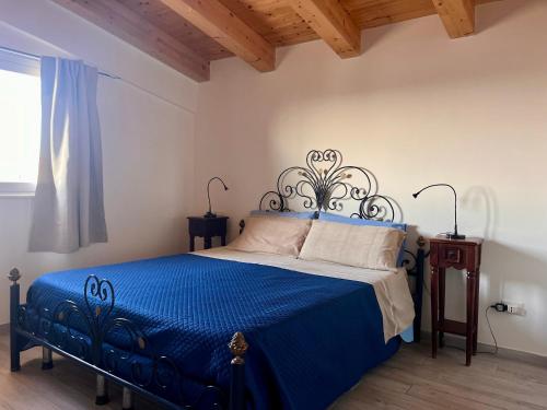 a bedroom with a bed with a blue comforter at The Blue Window - Rooms - 300m from sea in Augusta