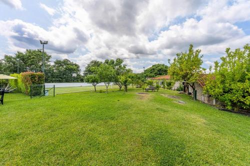 a green yard with a park with trees and a lake at Casa d'Amares in Amares
